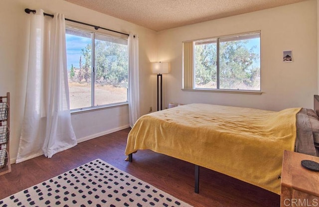 bedroom featuring a textured ceiling and dark hardwood / wood-style flooring