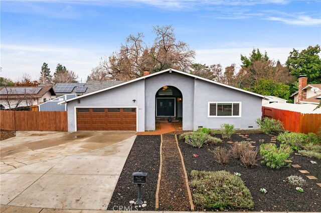 ranch-style home featuring a garage and solar panels