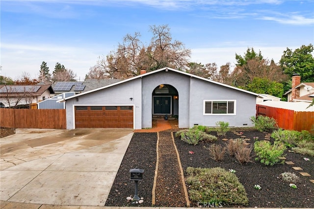 ranch-style house featuring a garage and solar panels