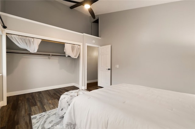 bedroom with dark hardwood / wood-style floors, a closet, ceiling fan, and a towering ceiling