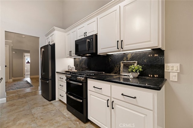 kitchen with white cabinetry, double oven range, stainless steel fridge, dark stone counters, and backsplash