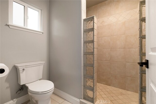 bathroom with tiled shower, tile patterned floors, and toilet