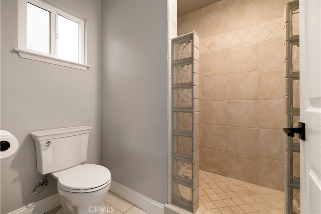 bathroom with a tile shower and toilet