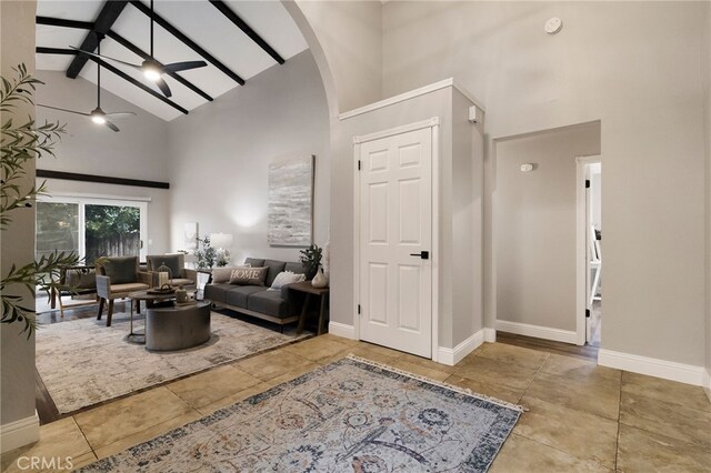 living room with ceiling fan, high vaulted ceiling, and beam ceiling