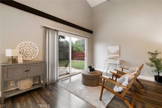 sitting room featuring a towering ceiling and dark hardwood / wood-style flooring