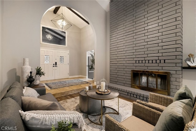 living room with hardwood / wood-style floors, a fireplace, and high vaulted ceiling