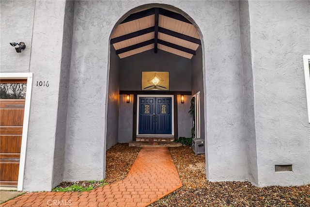 view of exterior entry featuring crawl space and stucco siding