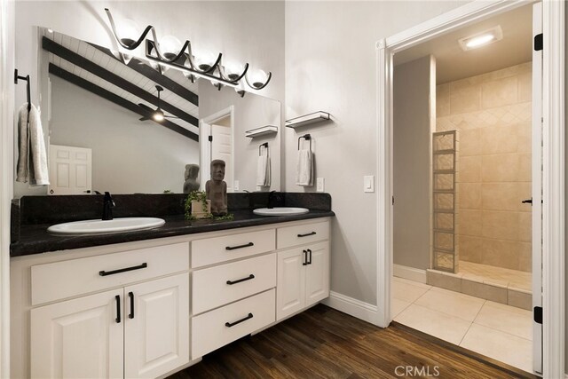 bathroom with tile patterned floors, vanity, and a tile shower