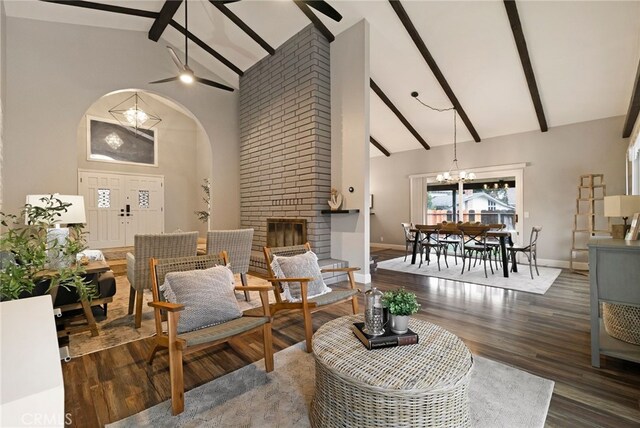 living room featuring beamed ceiling, dark hardwood / wood-style floors, a fireplace, and high vaulted ceiling