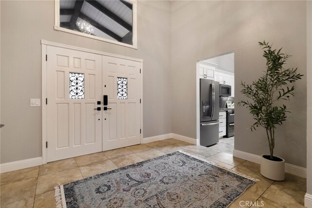 entrance foyer with lofted ceiling with beams, light tile patterned floors, and wood ceiling