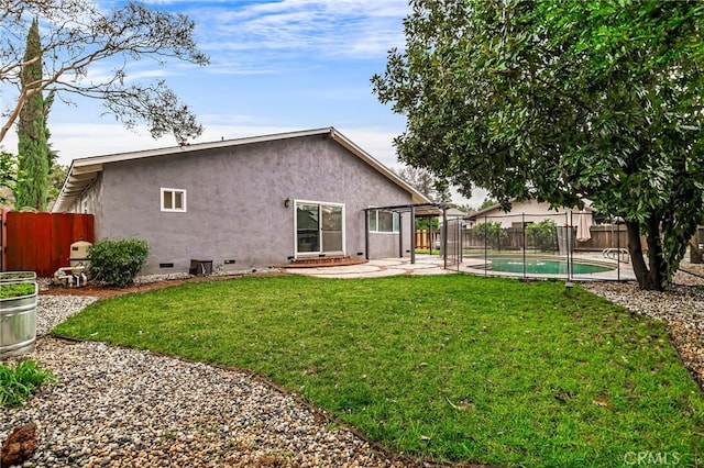 rear view of property with a yard, a fenced in pool, and a patio area