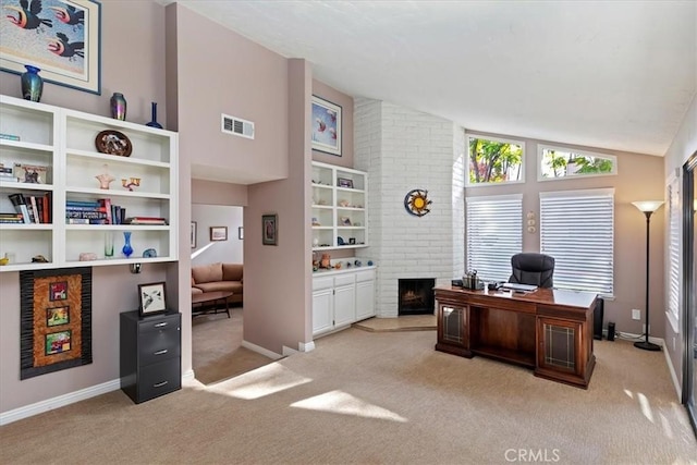 carpeted home office with lofted ceiling and a brick fireplace