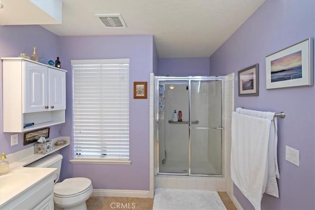 bathroom featuring toilet, tile patterned floors, walk in shower, and vanity