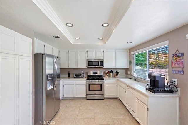 kitchen featuring a raised ceiling, light tile patterned flooring, sink, white cabinetry, and stainless steel appliances