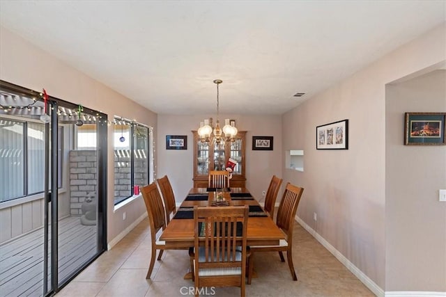 dining area with a notable chandelier and light tile patterned flooring