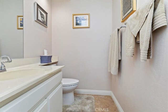 bathroom featuring toilet, vanity, and tile patterned flooring