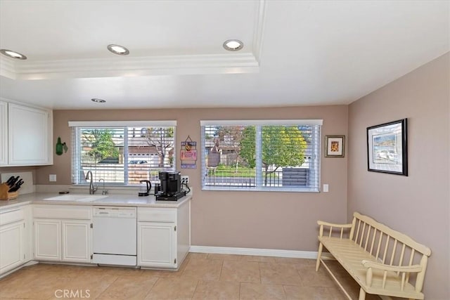 kitchen featuring white dishwasher, white cabinets, a tray ceiling, and sink