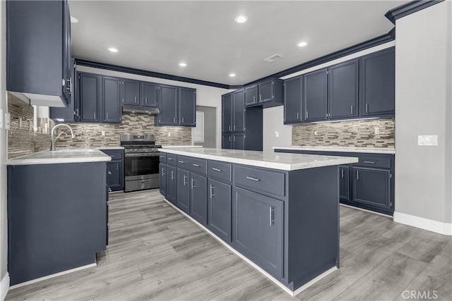 kitchen featuring a kitchen island, tasteful backsplash, sink, stainless steel stove, and crown molding