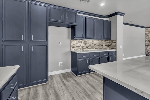 kitchen with decorative backsplash, crown molding, light hardwood / wood-style flooring, and light stone countertops