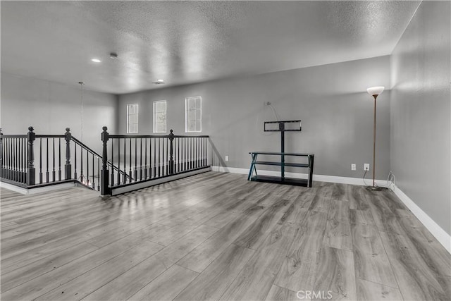 spare room with light hardwood / wood-style floors and a textured ceiling