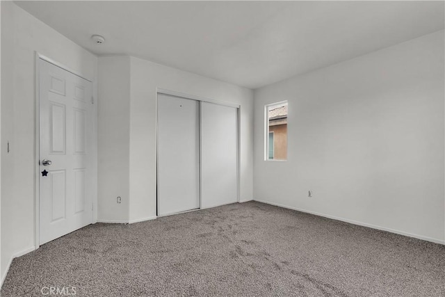 unfurnished bedroom with a closet and carpet floors