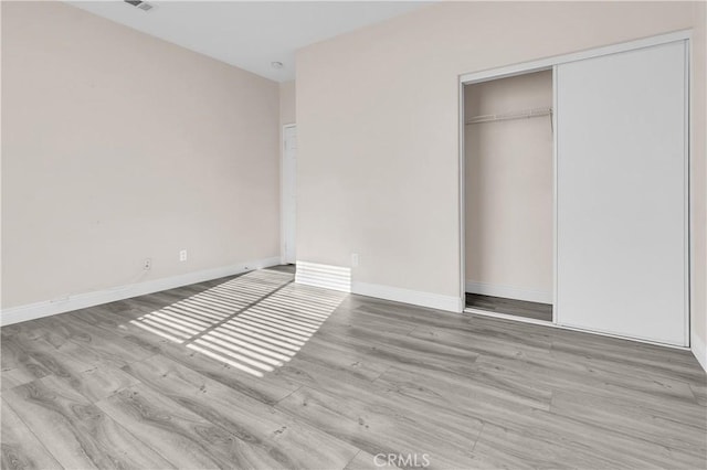 unfurnished bedroom featuring a closet and light hardwood / wood-style flooring