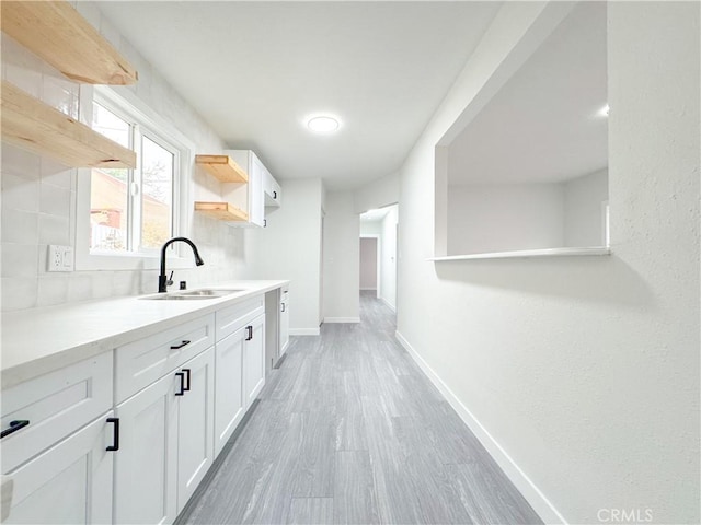 interior space with sink, white cabinetry, and hardwood / wood-style floors