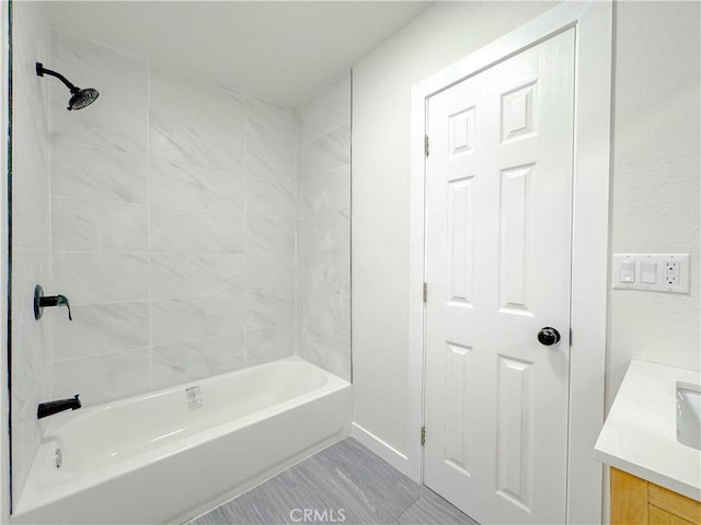 bathroom with tiled shower / bath combo and vanity