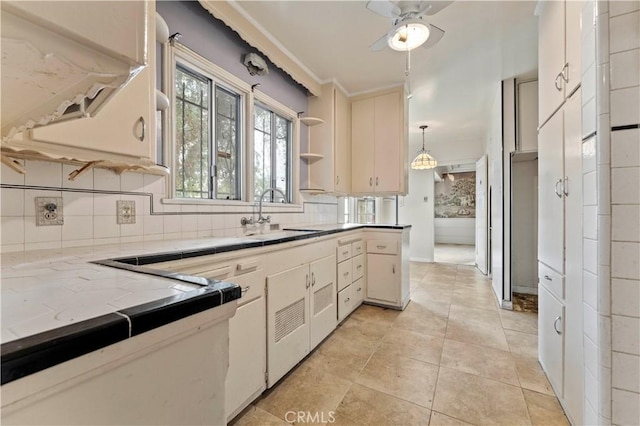 kitchen with sink, backsplash, hanging light fixtures, light tile patterned flooring, and ceiling fan