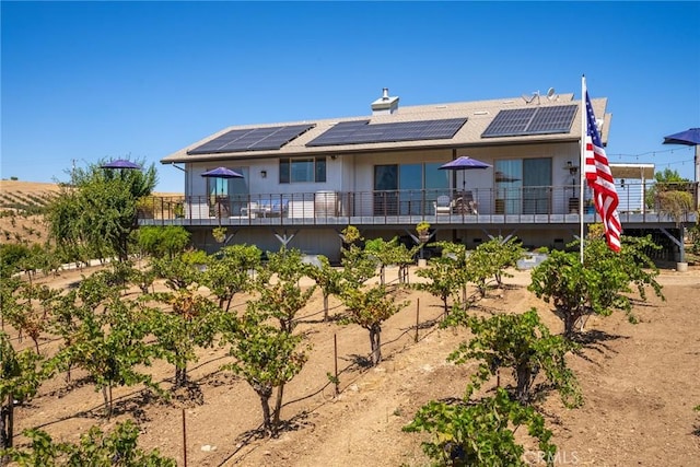 rear view of property featuring solar panels