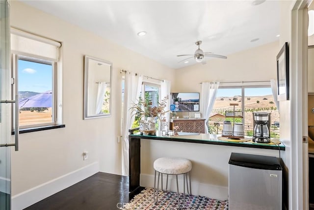 kitchen featuring baseboards, vaulted ceiling, recessed lighting, refrigerator, and a ceiling fan