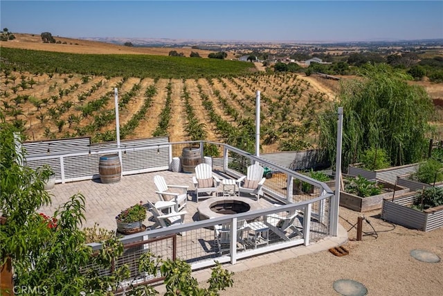view of patio / terrace featuring a garden, a fire pit, and a rural view