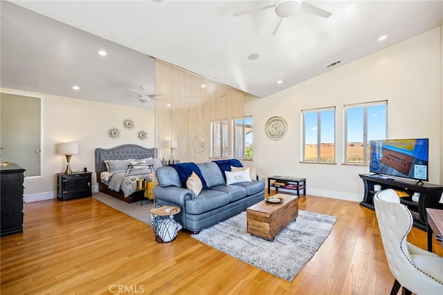 bedroom with ceiling fan, vaulted ceiling, and light wood-type flooring