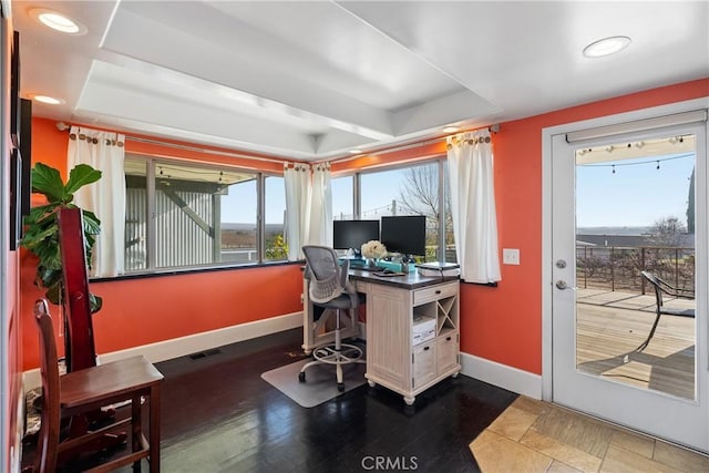 home office with a raised ceiling and a healthy amount of sunlight