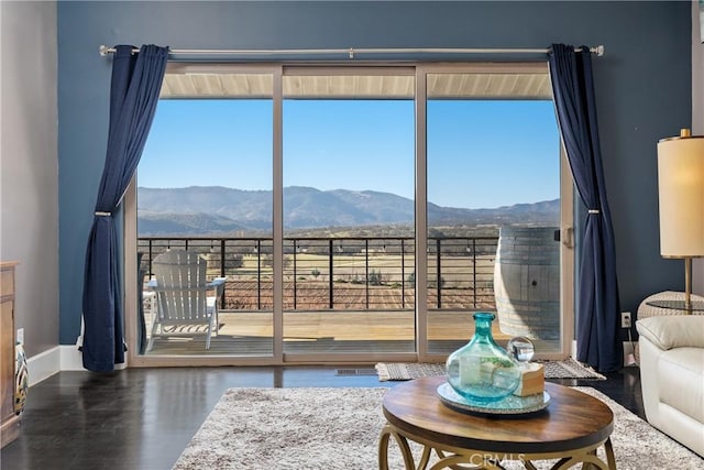 living area featuring a mountain view, baseboards, and wood finished floors