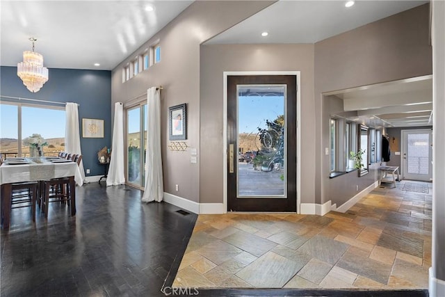 foyer with dark hardwood / wood-style flooring and a chandelier