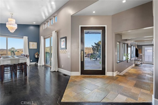 entryway featuring visible vents, baseboards, recessed lighting, stone tile flooring, and a notable chandelier