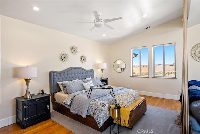 bedroom featuring hardwood / wood-style floors, vaulted ceiling, and ceiling fan