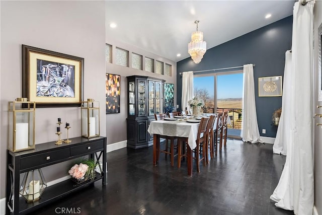 dining area with a notable chandelier, dark wood-type flooring, and vaulted ceiling