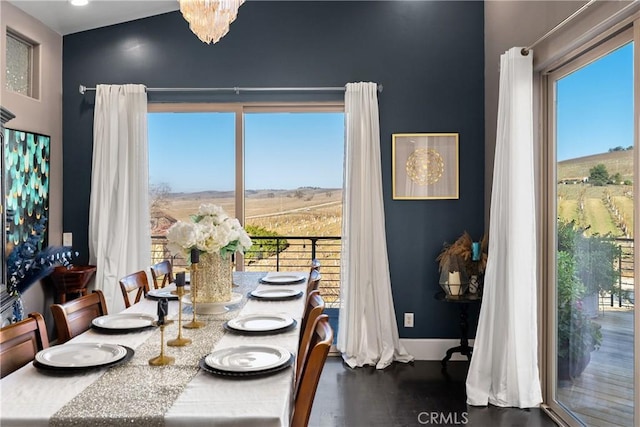 dining space with wood-type flooring, plenty of natural light, and an inviting chandelier