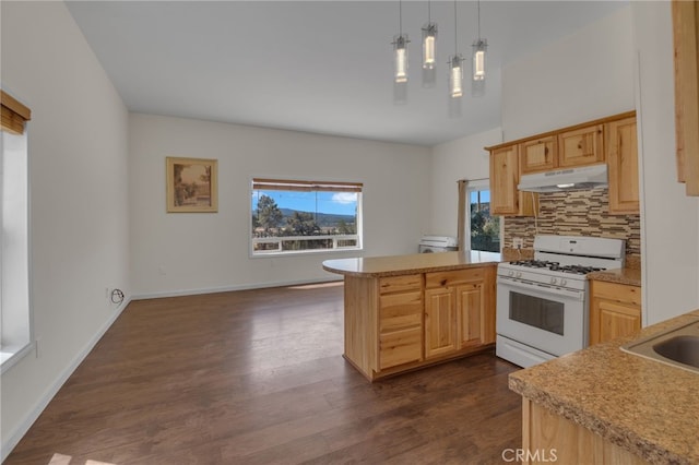 kitchen with light brown cabinets, hanging light fixtures, backsplash, kitchen peninsula, and white range with gas stovetop