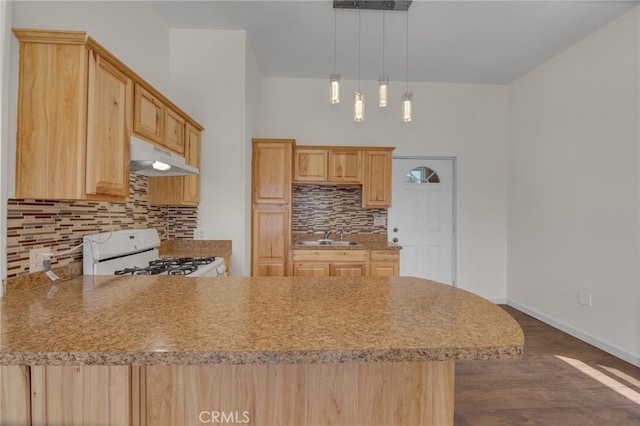 kitchen with tasteful backsplash, light brown cabinetry, hanging light fixtures, and white range with gas cooktop