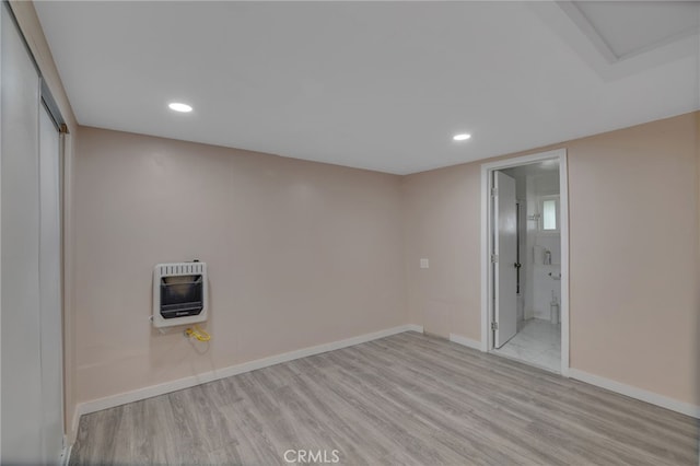 washroom featuring heating unit and light hardwood / wood-style flooring