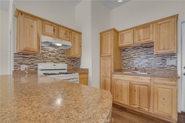 kitchen with light brown cabinetry, sink, and white range with gas cooktop