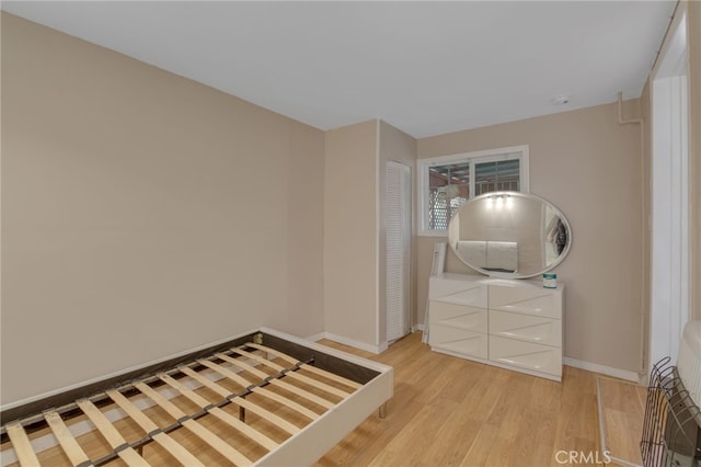 unfurnished bedroom featuring a closet and light hardwood / wood-style floors