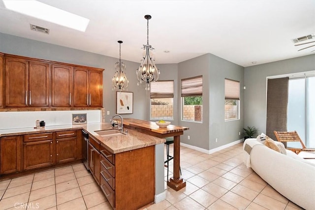 kitchen featuring an inviting chandelier, dishwasher, light stone countertops, pendant lighting, and sink