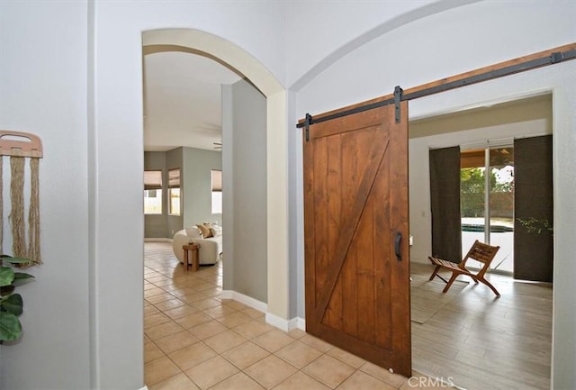 foyer entrance featuring light tile patterned floors and a barn door