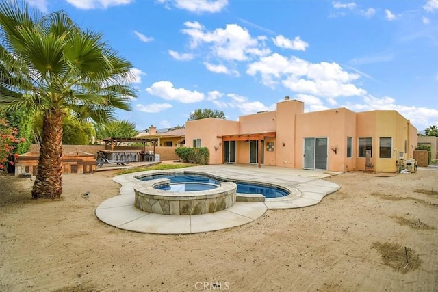 rear view of house featuring a swimming pool with hot tub, a patio, and a pergola