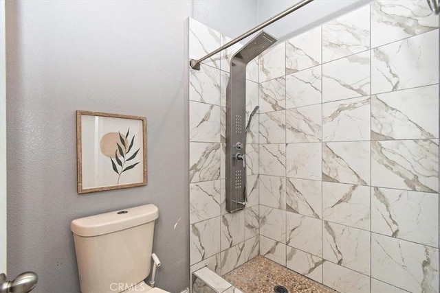 bathroom with toilet and tiled shower