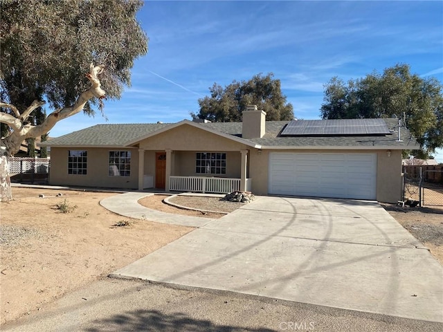 ranch-style house with a garage and solar panels